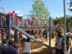 A photograph of a play feature at Discovery Green with a large crowd of children and parents.