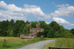 A photograph of an observation tower sited in one of the park's open meadows. The tower is made of wood and metal and is about one story high.