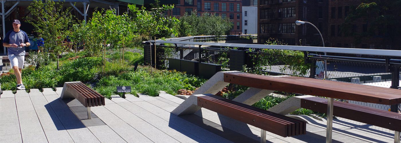 A cropped photograph of the High Line signature benches, in which the concrete paving "peels up" to become a bench with wood slats.